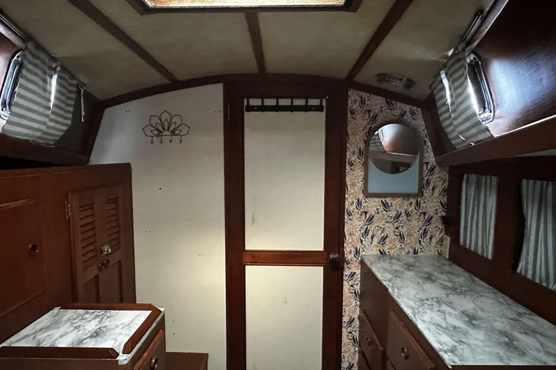 Slide: The Image of Interior of 1981 Pearson 424 sailboat with wood cabinetry and patterned wallpaper. - 24