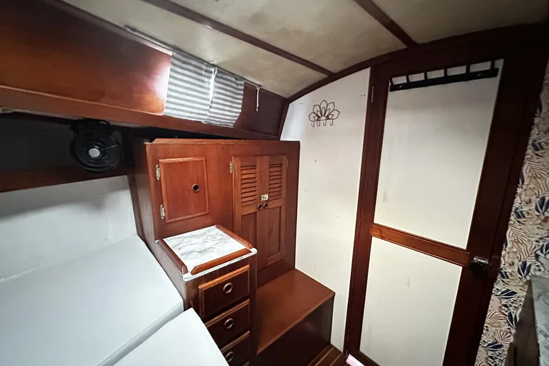 Slide: The Image of Interior of 1981 Pearson 424 sailboat with wooden cabinetry and cozy sleeping area. - 25
