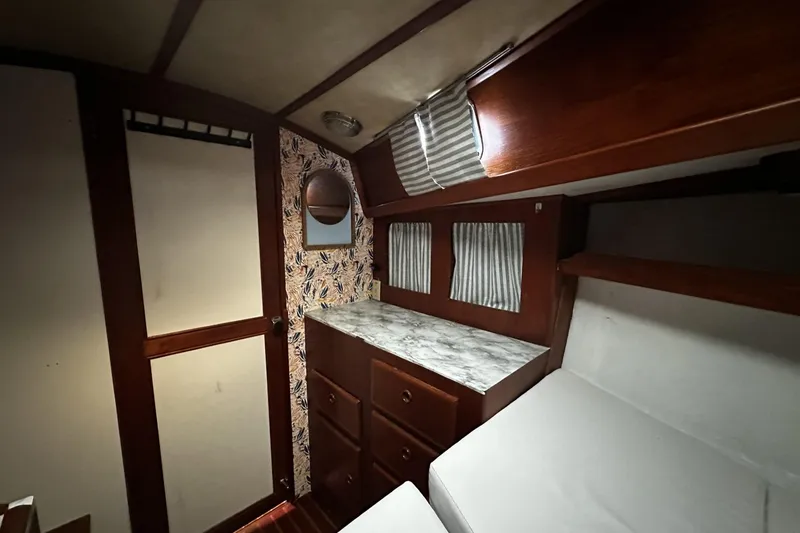 Slide: The Image of Interior of 1981 Pearson 424 sailboat cabin with wood finish and striped curtains. - 26