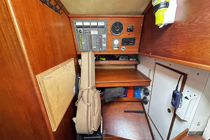 Slide: The Image of 1981 Pearson 424 sailboat navigation station with control panel and storage. - 28