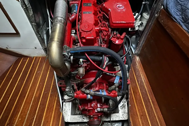 Slide: The Image of Engine compartment of a 1981 Pearson 424 sailboat, featuring a red marine engine. - 33