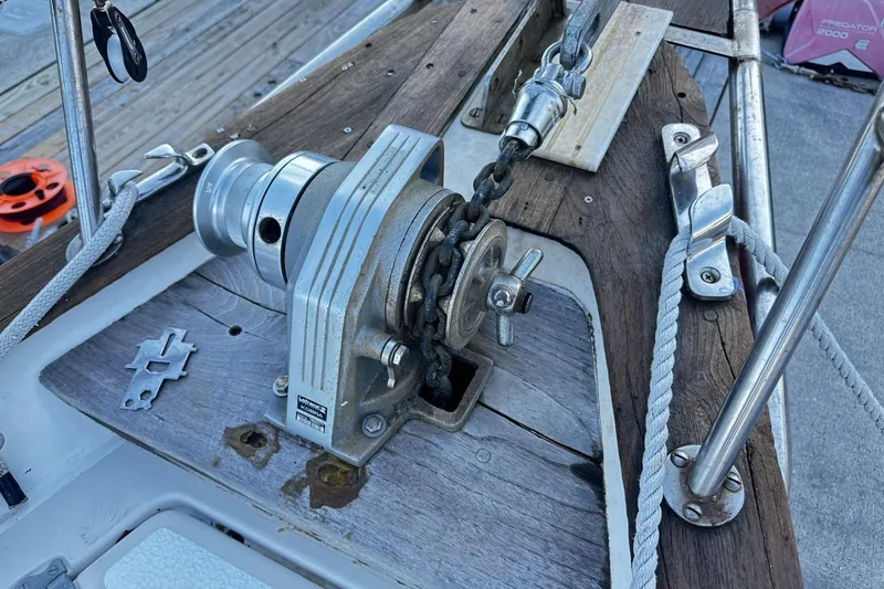Slide: The Image of Anchor windlass on 1981 Pearson 424 sailboat deck, featuring wooden and metal elements. - 38
