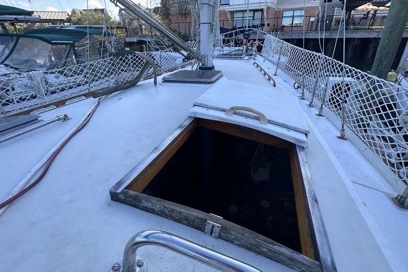 Slide: The Image of 1981 Pearson 424 sailboat deck with open hatch and safety netting. - 7