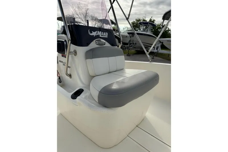 Slide: The Image of 2022 Mako Pro Skiff 15 CC boat interior with cushioned seating and steering console. - 10
