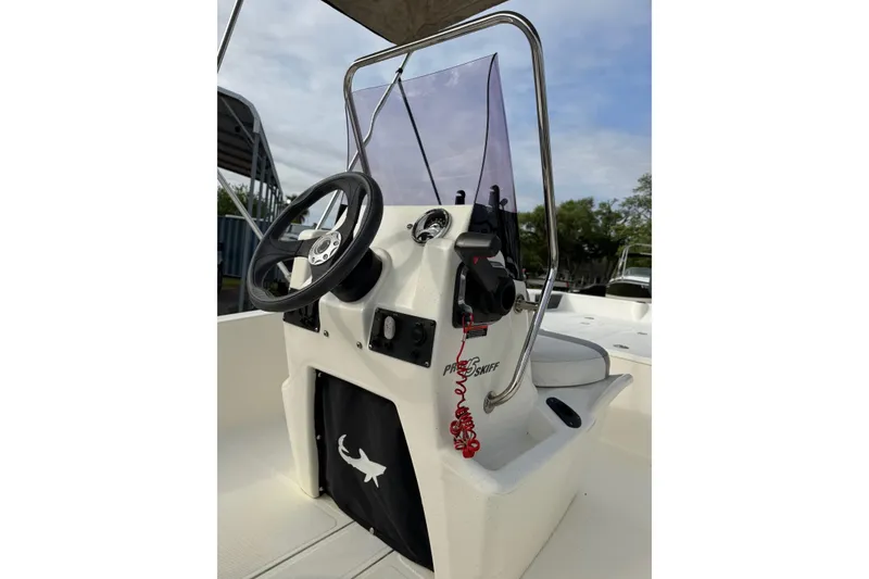 Slide: The Image of 2022 Mako Pro Skiff 15 CC boat console with steering wheel and controls. - 12