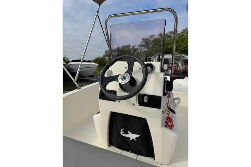 Slide: The Image of 2022 Mako Pro Skiff 15 CC boat console with steering wheel and windshield. - 13