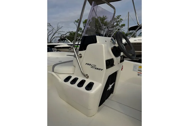 Slide: The Image of 2022 Mako Pro Skiff 15 CC boat console with steering wheel and controls. - 15