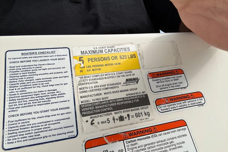 Slide: The Image of Boating safety and capacity labels on a 2022 Mako Pro Skiff 15 CC. - 16