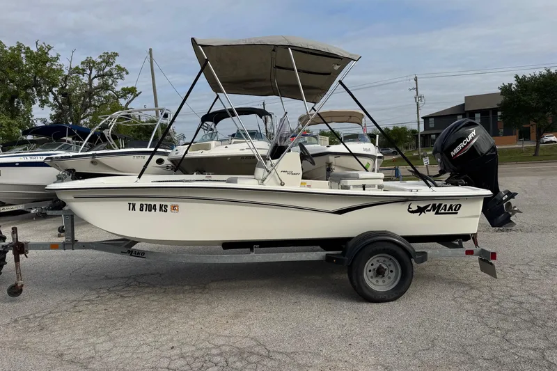 Slide: The Image of 2022 Mako Pro Skiff 15 CC boat on trailer with Mercury outboard motor. - 3
