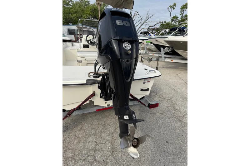 Slide: The Image of 2022 Mako Pro Skiff 15 CC with 60 HP outboard motor, parked on a trailer. - 5
