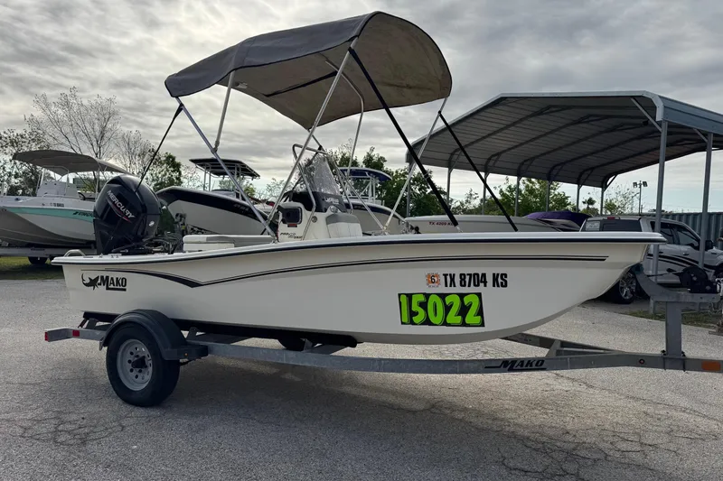 Slide: The Image of 2022 Mako Pro Skiff 15 CC boat on trailer with canopy, parked outdoors. - 7