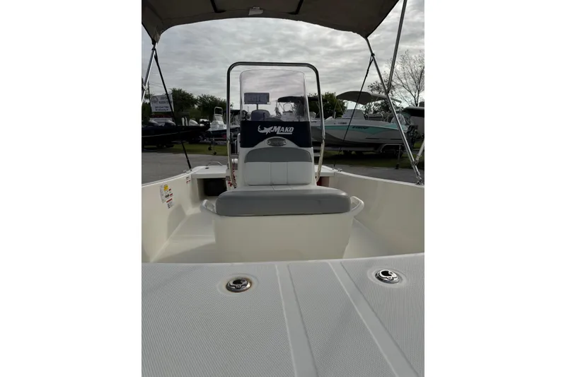 Slide: The Image of 2022 Mako Pro Skiff 15 CC boat interior with seating and console under canopy. - 9