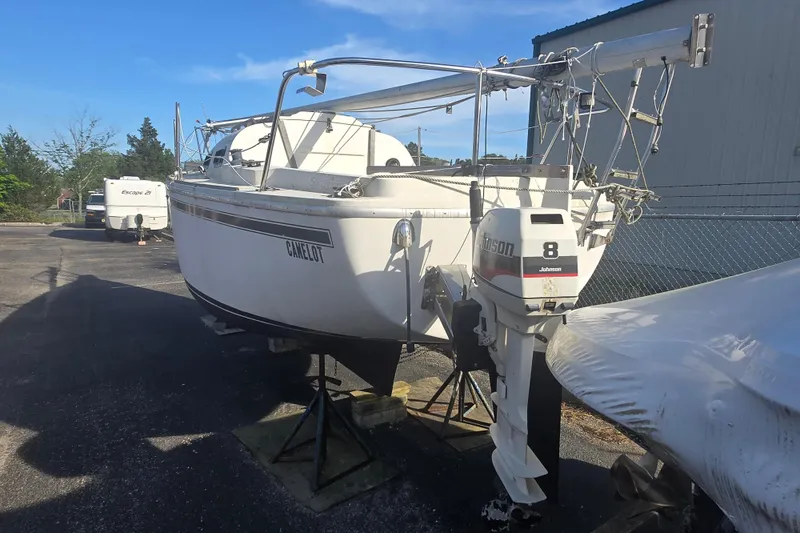 Slide: The Image of 1986 Sovereign 24 sailboat with Johnson 8 outboard motor, parked on a trailer. - 11