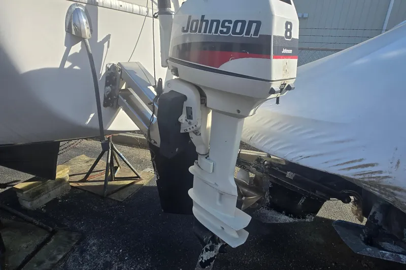 Slide: The Image of 1986 Sovereign 24 boat with Johnson 8 outboard motor, stored outdoors. - 12