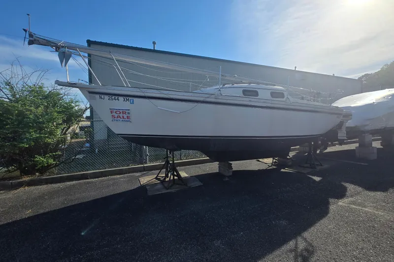 Slide: The Image of 1986 Sovereign 24 sailboat for sale, displayed on stands in a sunny outdoor setting. - 14