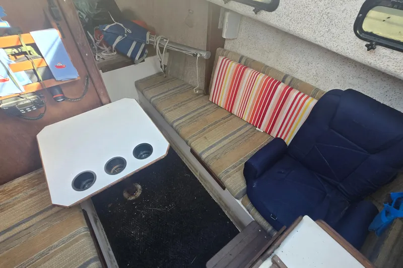 Slide: The Image of Interior of a 1986 Sovereign 24 sailboat with seating and a small table. - 18