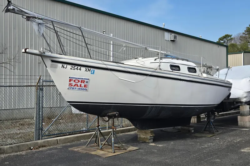 Slide: The Image of 1986 Sovereign 24 sailboat for sale, displayed on stands outside a warehouse. - 8