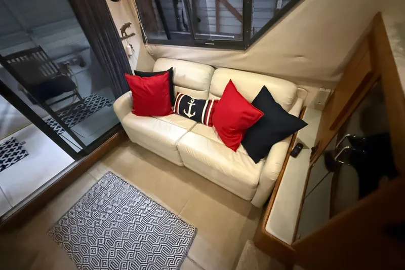 Slide: The Image of Interior of 1994 Carver 370 Voyager with white sofa and nautical-themed pillows. - 18