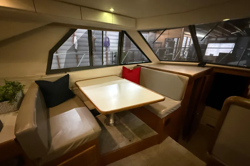 Slide: The Image of Interior of 1994 Carver 370 Voyager yacht with dining area and cushions. - 23