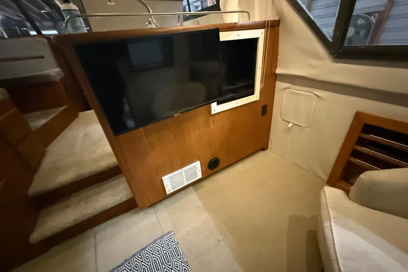 Slide: The Image of Interior of a 1994 Carver 370 Voyager with TV and wooden cabinetry. - 24