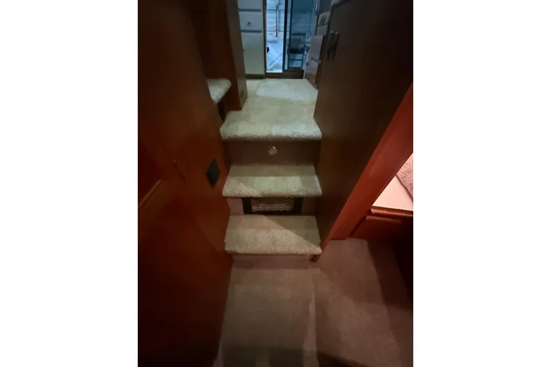 Slide: The Image of Interior stairs of a 1994 Carver 370 Voyager yacht, carpeted and leading to a cabin. - 28