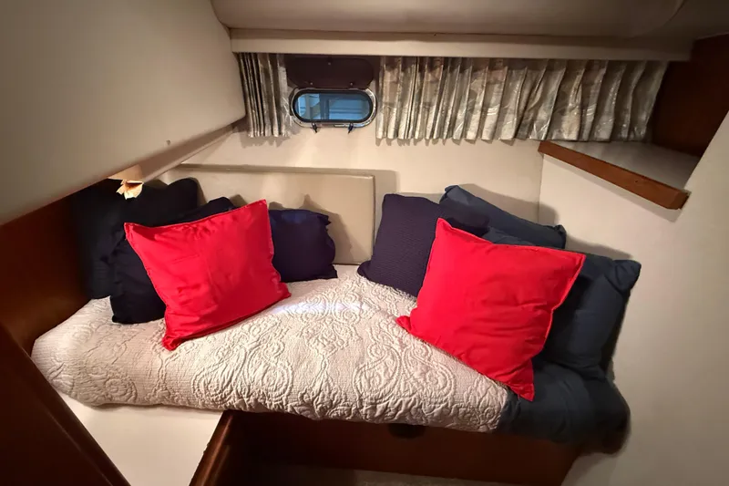 Slide: The Image of Cozy cabin interior of 1994 Carver 370 Voyager with colorful pillows and a small window. - 29