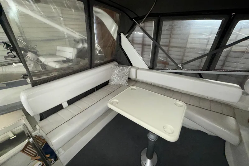 Slide: The Image of Interior of 1994 Carver 370 Voyager with white seating and table in enclosed cabin. - 3