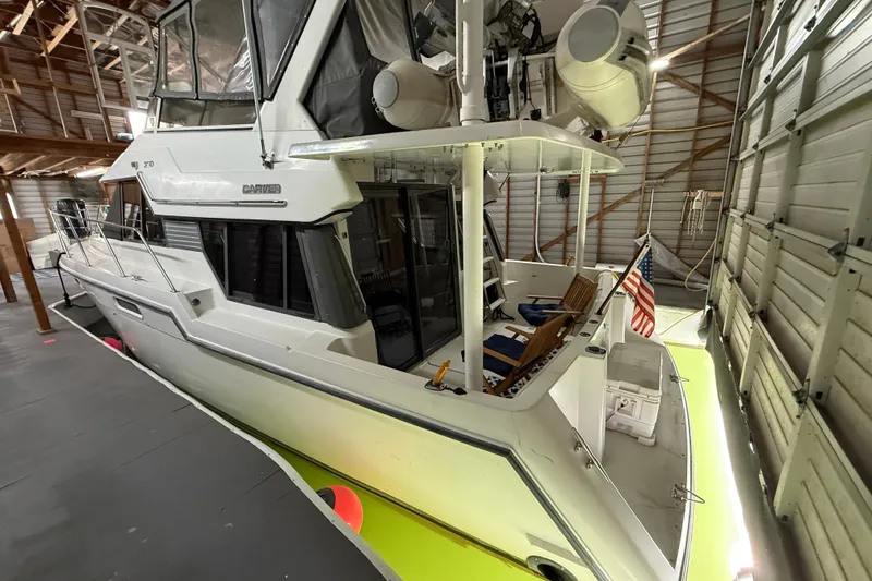 Slide: The Image of 1994 Carver 370 Voyager yacht docked in a spacious indoor marina. - 54