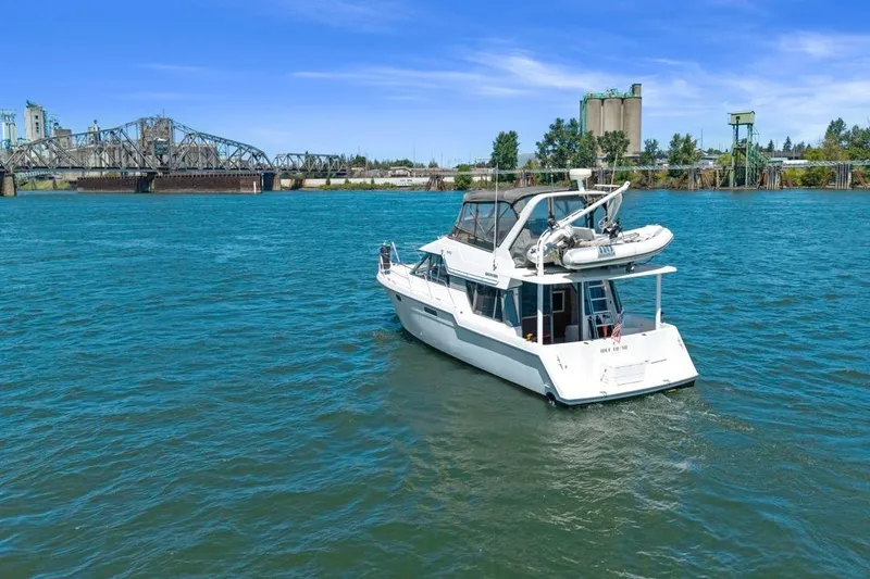 Slide: The Image of Carver 370 Voyager 1994 yacht cruising on a scenic river near a bridge. - 63