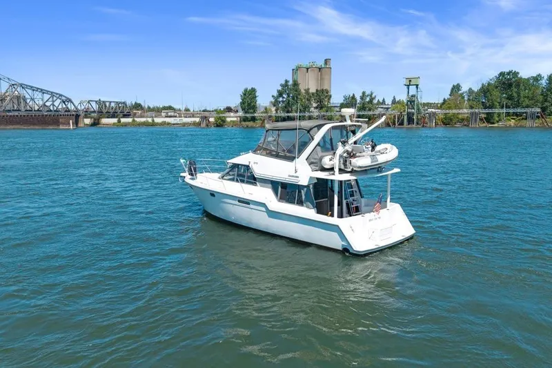 Slide: The Image of 1994 Carver 370 Voyager yacht on a river with industrial backdrop. - 64
