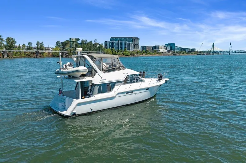 Slide: The Image of 1994 Carver 370 Voyager yacht cruising on a river with cityscape background. - 69