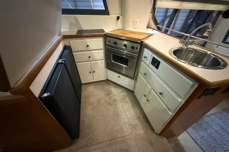 Slide: The Image of 1994 Carver 370 Voyager kitchen with stove, sink, and storage cabinets. - 7