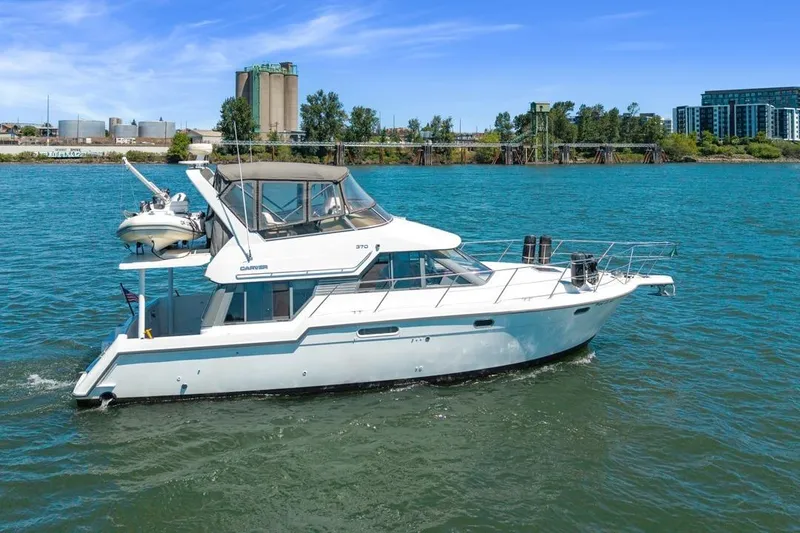 Slide: The Image of 1994 Carver 370 Voyager yacht cruising on a river with industrial backdrop. - 70
