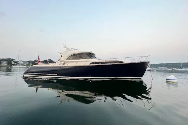 Slide: The Image of 2006 Mochi Craft 51 Dolphin yacht on calm water at sunset. - 4