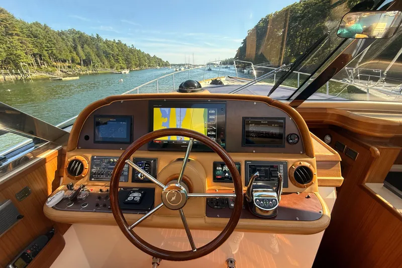 Slide: The Image of Helm of 2006 Mochi Craft 51 Dolphin yacht with navigation equipment and scenic waterway view. - 6