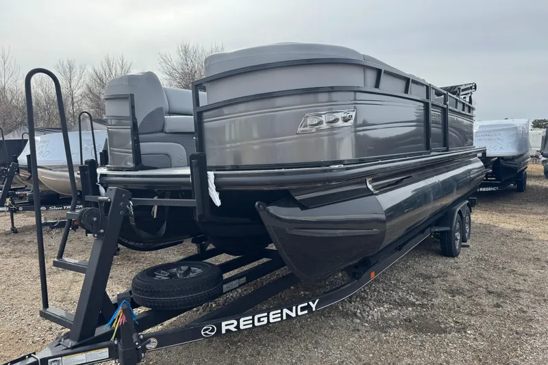 The Image of 2025 Regency 230 DL3 pontoon boat on trailer, displayed outdoors. - 1