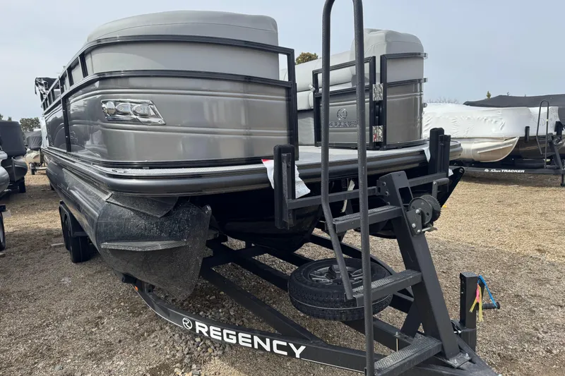 Slide: The Image of 2025 Regency 230 DL3 pontoon boat on trailer, side view. - 2