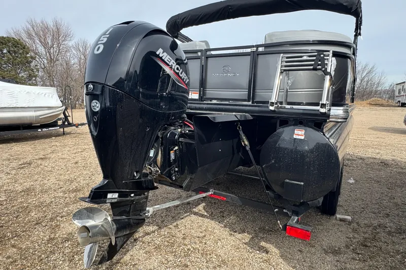 Slide: The Image of 2025 Regency 230 DL3 pontoon boat with Mercury 150 outboard motor, parked on gravel. - 4