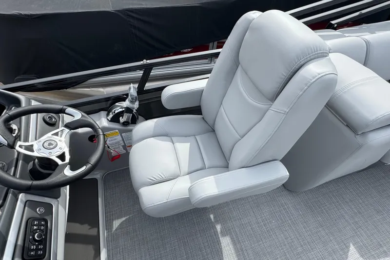 Slide: The Image of Captain's chair and steering wheel of 2025 Regency 230 DL3 boat, featuring sleek design. - 9