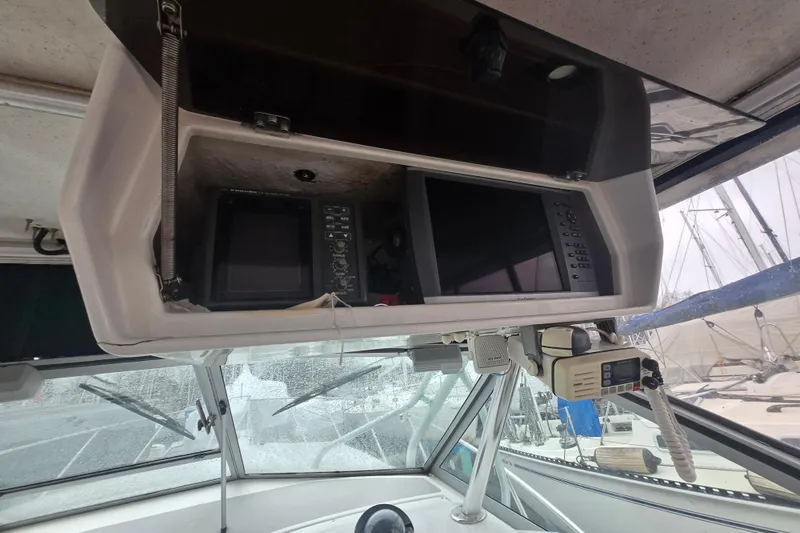 Slide: The Image of 1998 Wellcraft 330 Coastal boat cockpit with navigation equipment and radio system. - 10