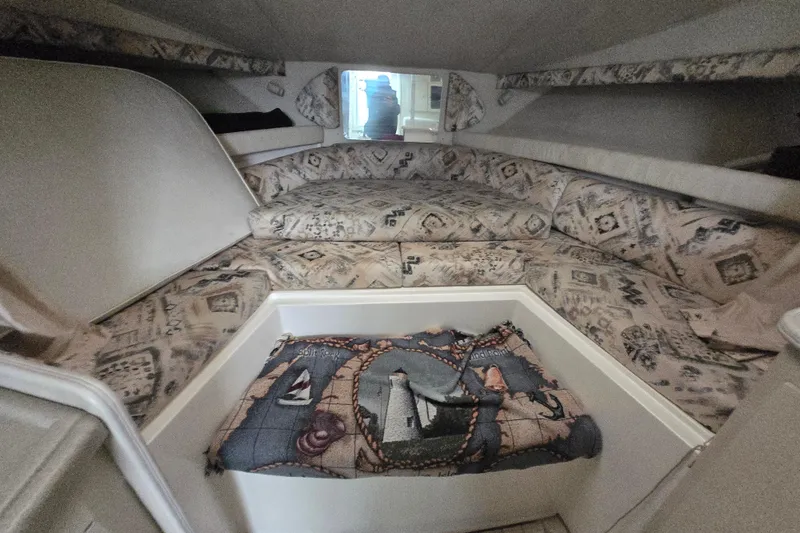 Slide: The Image of 1998 Wellcraft 330 Coastal cabin interior with patterned cushions and nautical-themed decor. - 11