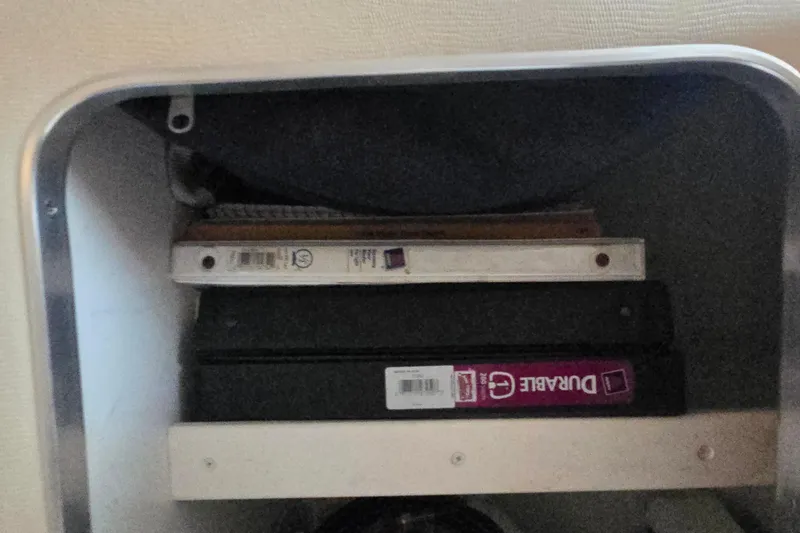 Slide: The Image of Storage compartment with binders inside a 1998 Wellcraft 330 Coastal boat. - 14