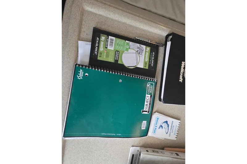 Slide: The Image of Notebooks and planner on Wellcraft 330 Coastal 1998 boat interior surface. - 18