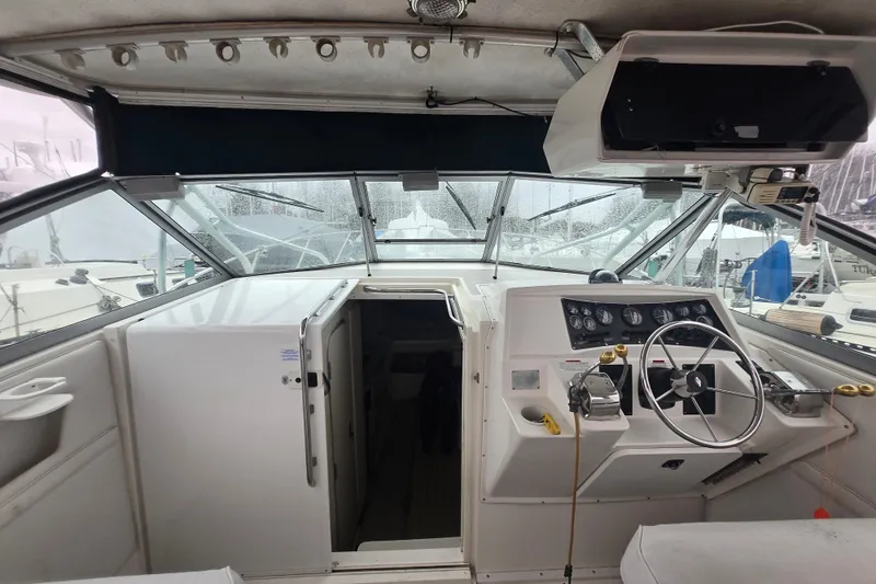 Slide: The Image of 1998 Wellcraft 330 Coastal boat cockpit with steering wheel and control panel. - 2