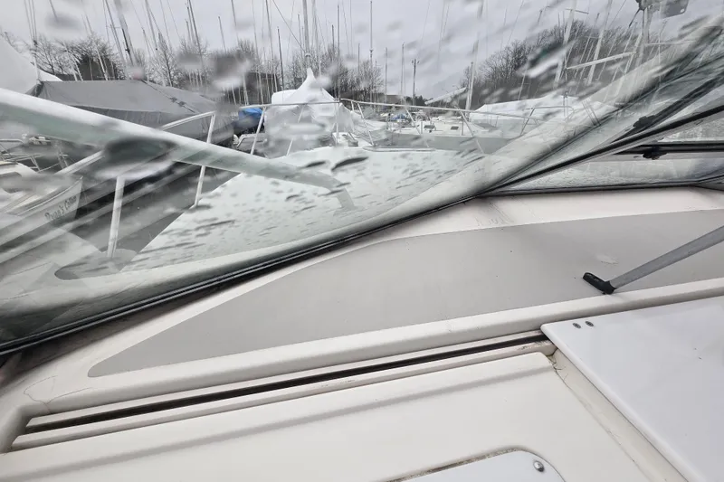 Slide: The Image of 1998 Wellcraft 330 Coastal boat windshield view with raindrops, docked among other boats. - 20