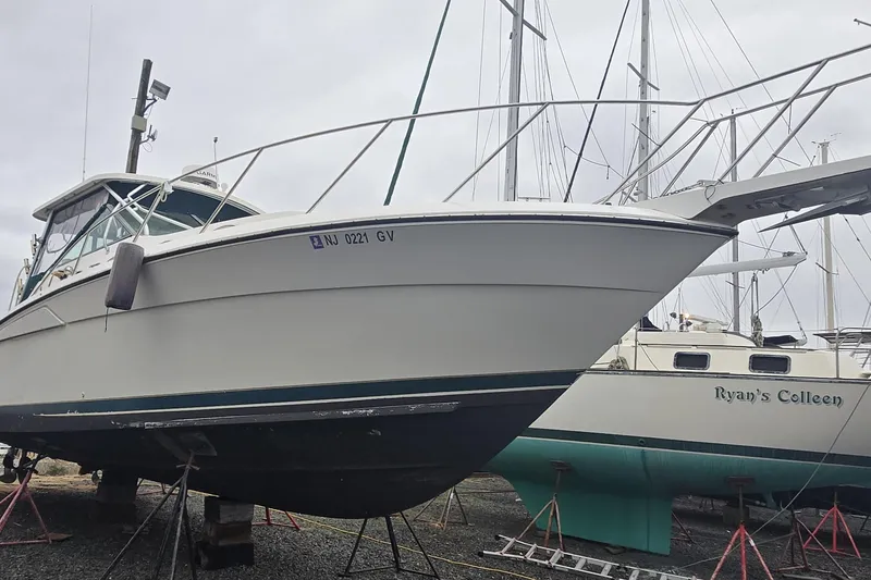 Slide: The Image of 1998 Wellcraft 330 Coastal boat on dry dock, side view with other boats nearby. - 21