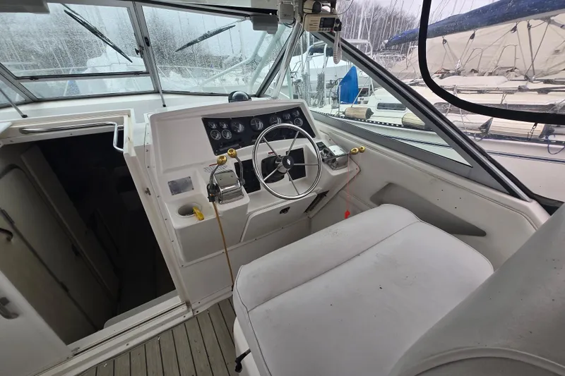 Slide: The Image of 1998 Wellcraft 330 Coastal boat cockpit with steering wheel and control panel. - 3