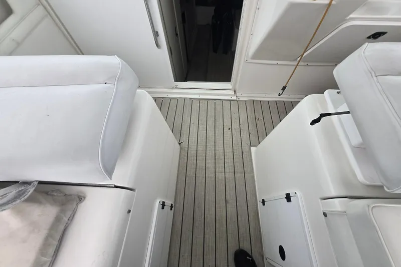 Slide: The Image of Interior view of a 1998 Wellcraft 330 Coastal boat with white seating and wooden flooring. - 9