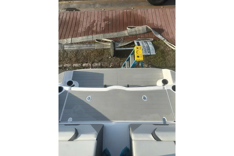 Slide: The Image of 2025 Yamaha Boats AR220 swim platform with cup holders, dockside view. - 11