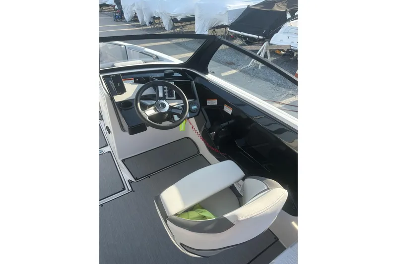 Slide: The Image of 2025 Yamaha Boats AR220 cockpit with steering wheel and captain's chair. - 13